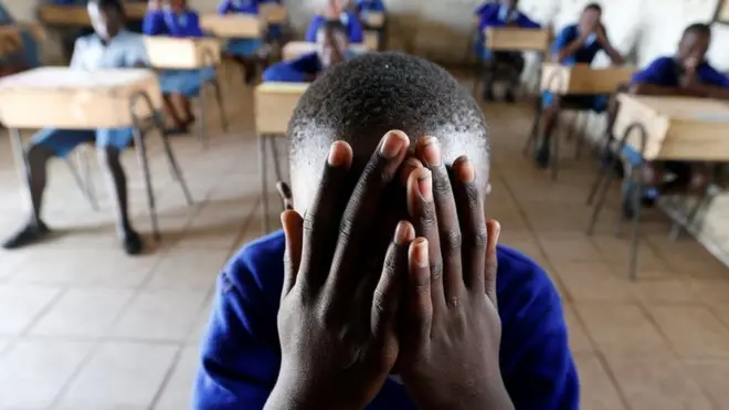 A pupil prays inside a classroom ahead of the primary school final national examinations at Kiboro Primary school along Juja road in Nairobi, Kenya October 31, 201