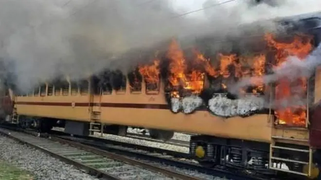 నిరసనకారులు నిప్పుపెట్టడంతో తగలబడిపోతున్న ప్యాసింజర్‌ రైలు