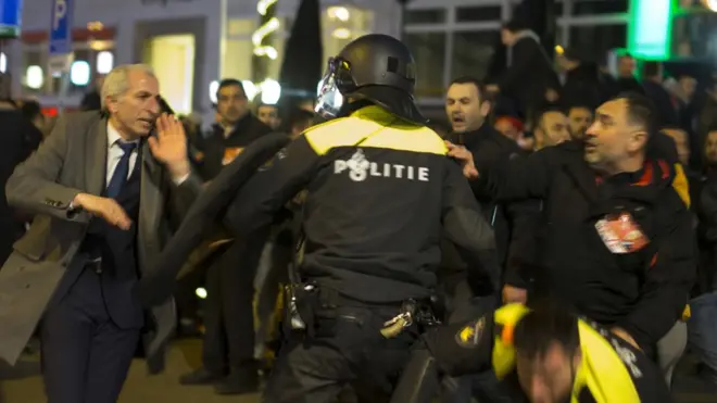 Un policía holandés intenta controlar una protesta de turcos en Rotterdam.
