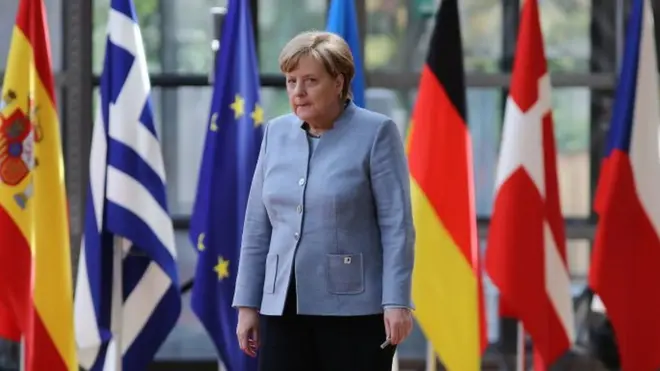 La canciller alemana, Ángela Merkel, camina hacia el lugar donde se firmó el borrador con los lineamientos.