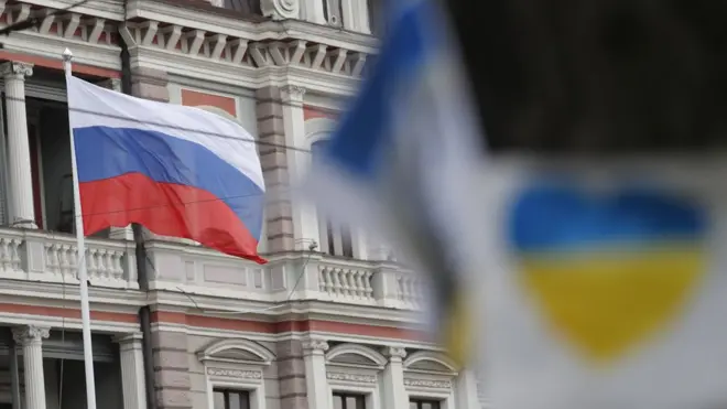 Russian and Ukranian flags outside the Russian Embassy in Riga