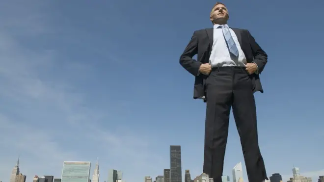 Tall man towering over city landscape