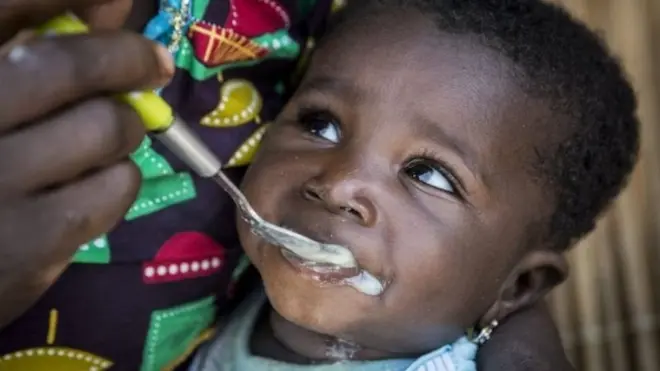 Un enfant qui mange de la bouillie.