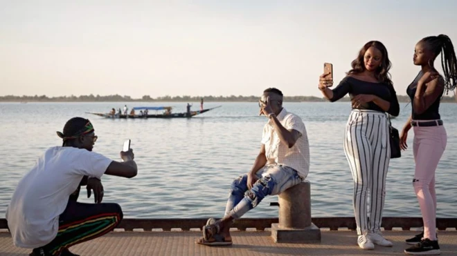 De jeunes maliens se prennent en photo sur les rives du fleuve Niger alors qu'ils assistent à un festival artistique à Ségou.