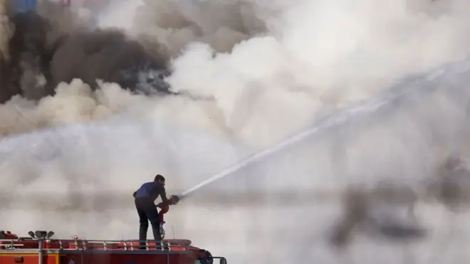 Пожежник намагається загасити пожежу в зруйнованій будівлі. Місто Іскендерун, Туреччина.