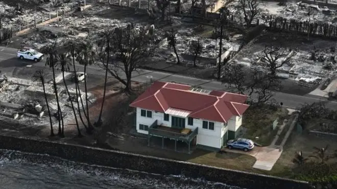 A red-roofed house was spared from the Lahaina fires while many others were reduced to rubble