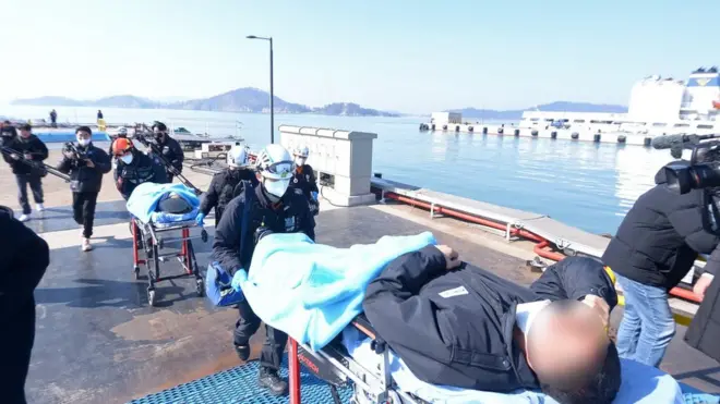 5일 오전 전남 신안군 해상에서 전복된 청보호에서 구조된 유모씨(48)와 손모씨(40), 인도네시아인 국적 A씨가 목포 북항에서 병원으로 이송되고 있다