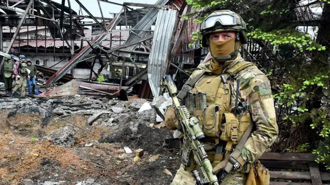 A Russian serviceman stands guard at the destroyed part of the Ilyich Iron and Steel Works in Ukraine's port city of Mariupol