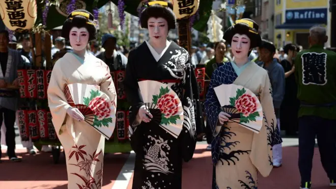 Women in kimono pose for a photograph in the street of Asakusa during Sanja festival on May 19, 2019