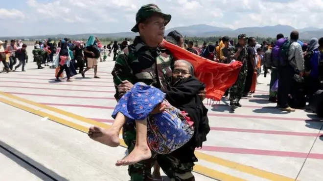 An Indonesian soldier carries an elderly woman evacuated after an earthquake and tsunami at Mutiara Sis Al Jufri airport in Palu, Central Sulawesi, Indonesia, October 1, 2018 in this photo taken by Antara Foto