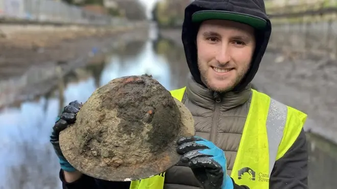 Mike Walker menendang benda bulat di perairan dangkal dan menemukan helm peninggalan Perang Dunia II.