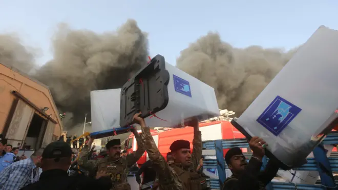 رجال الأمن يحملون صناديق الاقتراع