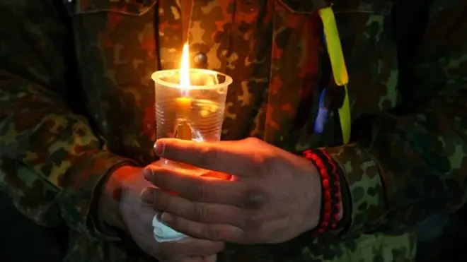 військовий тримає свічку