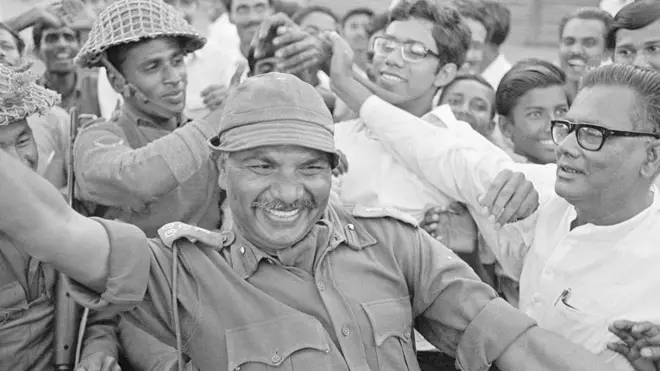 ब्रिगेडियर जनरल आर मिश्रा पूर्वी बंगालियों से घिरे हुए हैं. आर मिश्रा ढाका में भारतीय सेना का नेतृत्व कर रहे थे. 14 दिनों तक पाकिस्तान से चले युद्ध के बाद युद्धविराम पर सहमति बनी थी और बांग्लादेश का जन्म हुआ था.