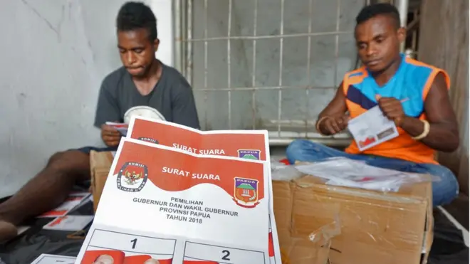 Petugas melipat surat suara pilkada Papua di Kantor KPU Mimika, Papua, Senin (18/6). Pilkada gubernur dan wakil gubernur Papua diikuti dua pasangan calon yakni Lukas Enembe - Klemen Tinal dan Jhon Wempi Wetipo - Habel Melkias Suwae