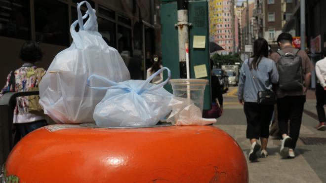 香港灣仔莊士敦道電車路旁一個垃圾桶上放滿了被裝在塑料袋內棄置的外賣飯盒（BBC中文圖片9/5/2024）