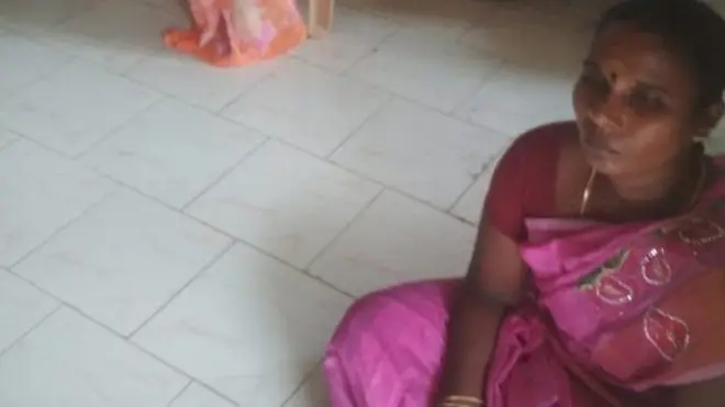 ज़मीन पर बैठी महिला