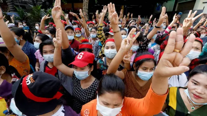 Protesters in Yangon flash the three-finger salute which has become a symbol of defiance in the region