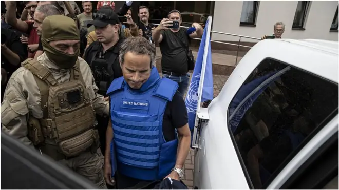 Мужчина в голубом жилете ООН садится в машину