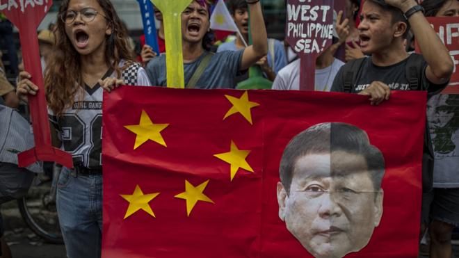 JULY 12: Filipinos hold a mock Chinese flag with a collage of the faces of Philippine President Rodrigo Duterte and Chinese President Xi Jinping during an anti-China protest outside the Chinese Embassy on July 12, 2019 in Makati, Metro Manila