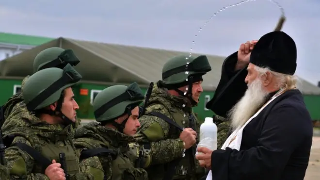 Sveštenik blagosilja regrute „svetom vodicom" u kampu za obuku u sklopu mobilizacije u Rostovu, 31. oktobra, 2022. godine