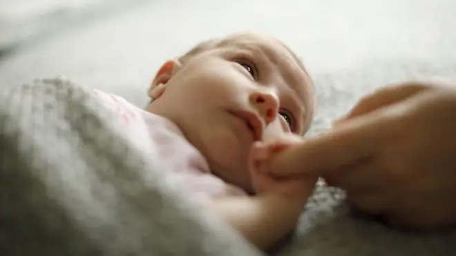 Mãe segurando mãocomo jogar na lotofácil onlinebebê