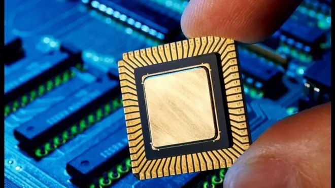 Hand holding computer chip, close-up