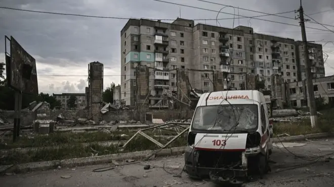 Ruined apartment block and ambulance in war-torn Lysychansk, 18 Jun 22