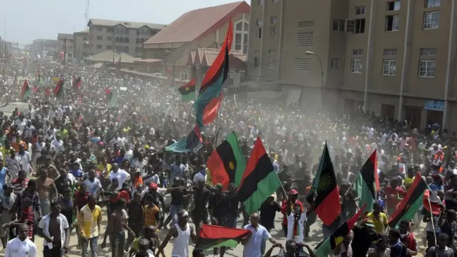 Hundreds of Biafra supporters wey dey wave flags.