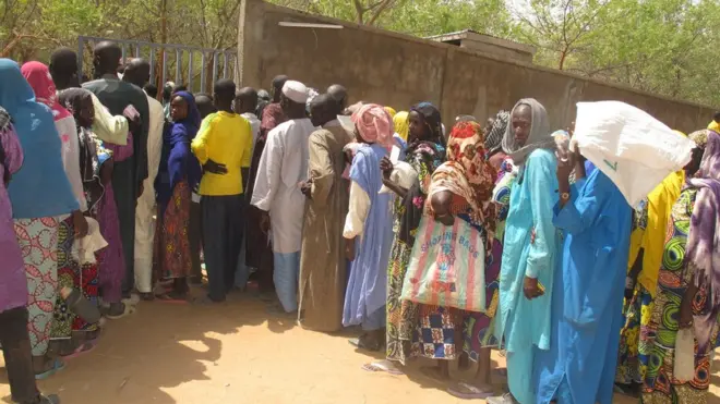 internally displaced people queue for camp inside Kolofata, wey dey north of Cameroon, for a food sharing wey International Red Cross Committee provide.