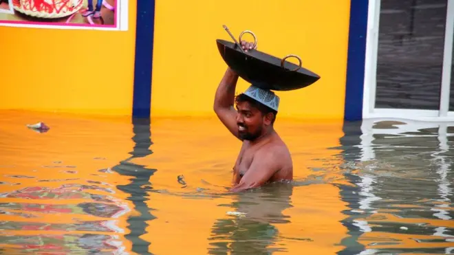 اترپردیش کے شہر الہٰ آباد میں ایک ریستوران کا ملازم سیلاب کی وجہ سے سامان منتقل کر رہا ہے