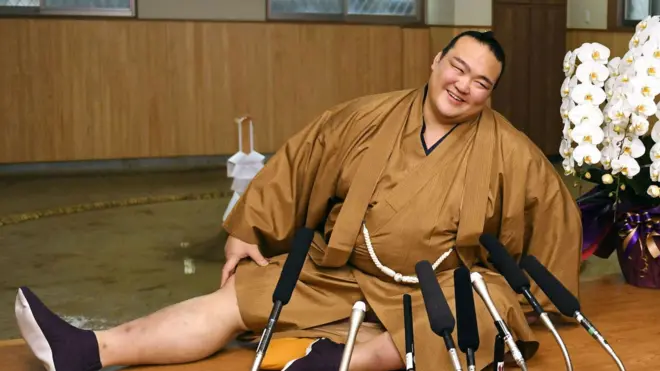 New Year Grand Sumo Tournament winner Kisenosato Yutaka stretches his legs during a press conference at his Tagonoura stable in Tokyo on 23 January 2017