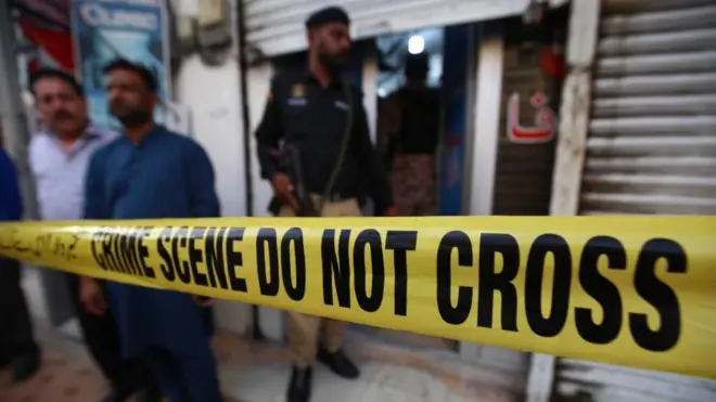 Security officials inspect the scene after an unidentified assailant opened fire inside a dental clinic run by Chinese nationals, in Karachi, Pakistan