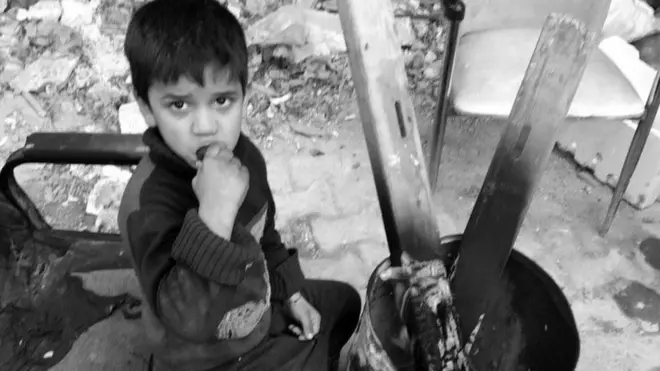 Eating a super fresh cucumber and keeping warm. During the siege of East Aleppo, farmers could not bring in produce