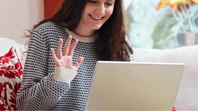 فتاة تتحدث عبر الفيديو من خلال كمبيوتر محمول