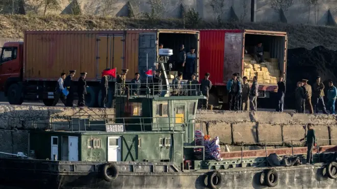 신의주에서 선박에서 트럭으로 화물을 옳겨 담는 북한 노동자들