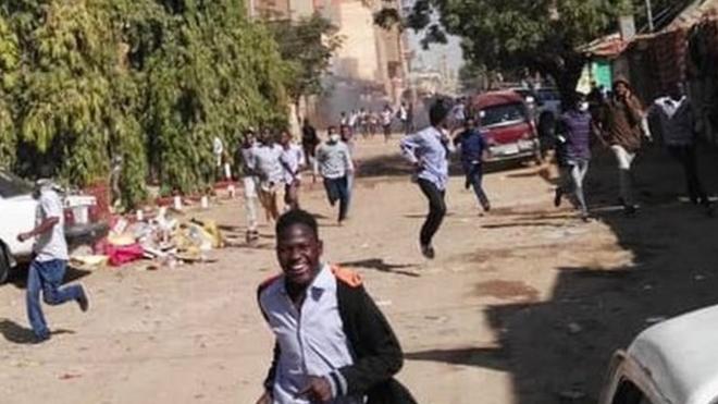 متظاهرون يفرون من قنابل الغاز المسيل للدموع في الخرطوم