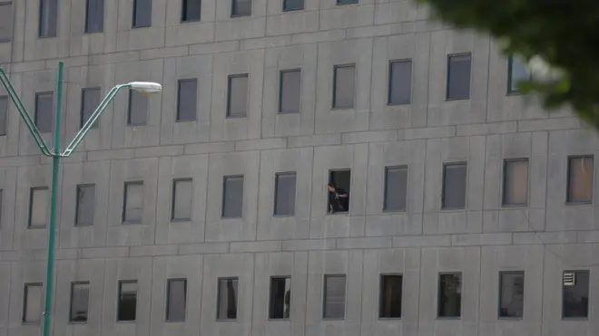 Полицейский, выглядывающий из окна здания парламента Ирана