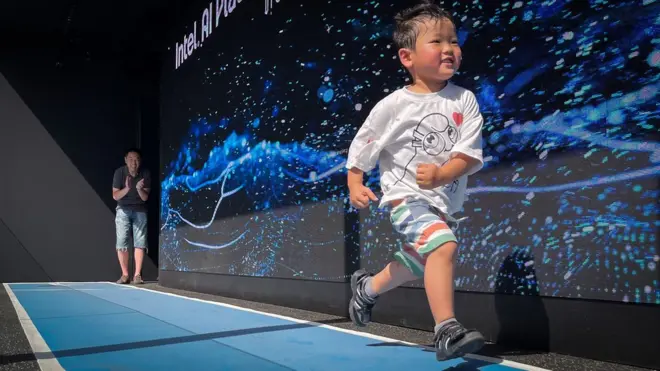 Dečak trči uz veliki ekran