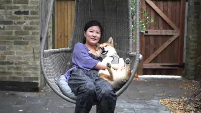 Meena holds Gus a rescue dog from a South Korean dog meat farm.