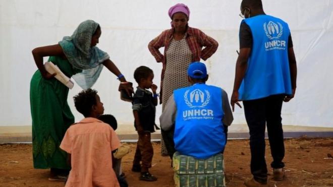 سيدتان وأطفال إثيوبيون مع عامل من المفوضية السامية للأمم المتحدة لشؤون اللاجئين