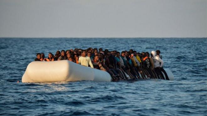 Migrants and refugees sit on a rubber boat before to be rescued by the ship Topaz Responder run by Maltese NGO Moas and Italian Red Cross off the Libyan coast in the Mediterranean Sea, on November 3, 2016