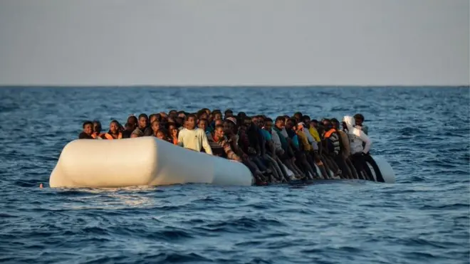 Migrants and refugees sit on a rubber boat before to be rescued by the ship Topaz Responder run by Maltese NGO Moas and Italian Red Cross off the Libyan coast in the Mediterranean Sea, on November 3, 2016