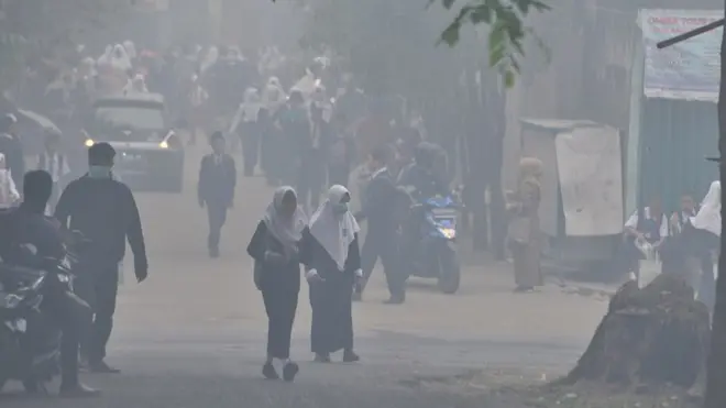 Sejumlah siswa SMP pulang lebih awal usai diumumkannya libur terkait kondisi kabut asap yang pekat di Palembang, Sumatera Selatan, Senin (14/10). Kondisi kabut asap yang sangat pekat membuat Dinas Pendidikan setempat mengeluarkan pemberitahuan bagi sekolah untuk meliburkan sekolah.