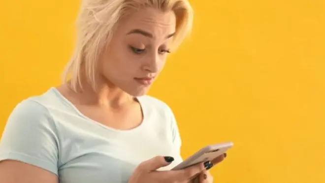 మొబైల్ ఫోన్ రెండు చేతులతో పట్టుకున్న యువతి