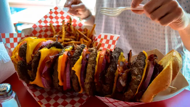 A huge stacked burger and fries