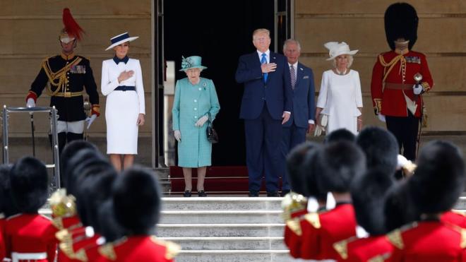 First Lady Melania Trump, Britain"s Queen Elizabeth II, US President Donald Trump, Britain"s Prince Charles, Prince of Wales and Britain"s Camilla, Duchess of Cornwall stand on the steps as the US national anthem plays during a welcome ceremony at Buckingham Palace