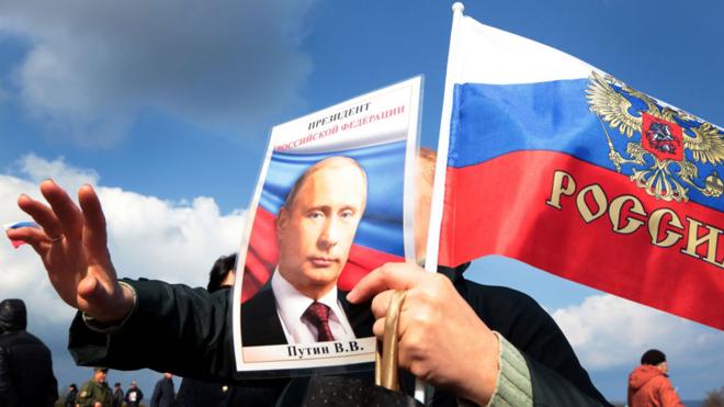 Demonstrator holding image of Putin