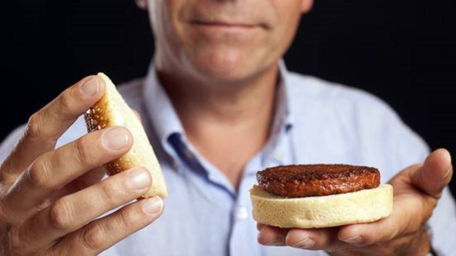 Homem segura pão com hambúrguer