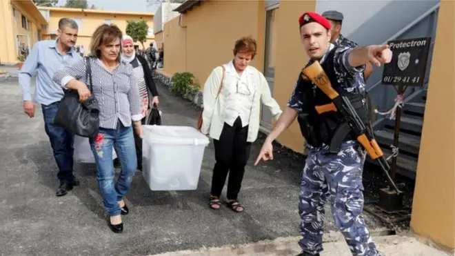 Askari wa Lebanoni akiwaonesha maafisa wa uchaguzi mahali pa kupeleka sanduku la kura